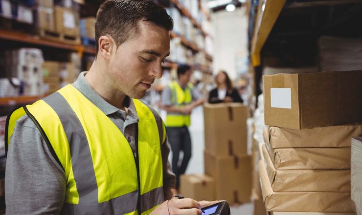 Warehouse worker scanning box in warehouse